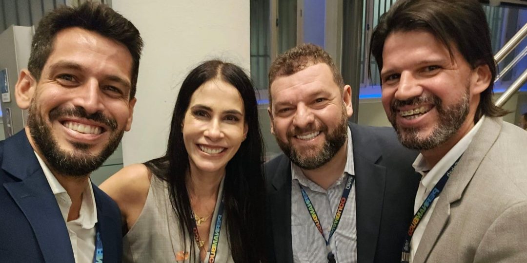Quatro pessoas reunidas uma ao lado da outra em pose para fotografia